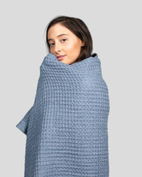 A woman wrapped in the ONSEN Denim Waffle Bath Towel.