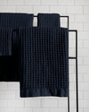 The ONSEN Twilight Blue Waffle Bath Sheet Move in set hanging on a rack.