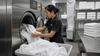 A hotel worker doing the laundry of white towels.