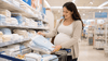A pregnant woman buying baby towels.