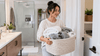 An Asian mother holding a basket full of towels.