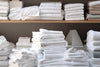 Neatly folded towels and linens representing proper towel care and maintenance. How Often Should You Change Your Towels.
