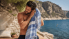 A man using a turkish towel on the beach.