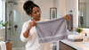 A black woman holding a hand towel.