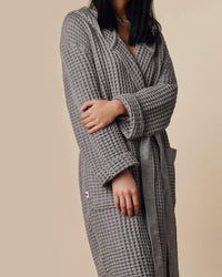 A close-up image of a woman wearing the ONSEN Cinder Grey Waffle Bath Robe.
