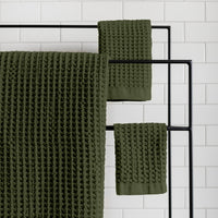 The ONSEN Forest Waffle Towel Complete Set hanging on a rack.