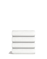 Sculpted Terry Hand Towels stacked neatly, showcasing their plush texture and fast-drying design in a clean white color.