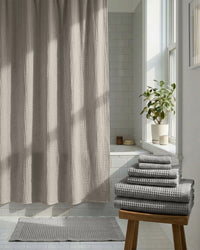 Gray shower curtain and towels in a bathroom setting