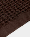 A close-up image of the ONSEN Brown Waffle Towel on a white background. 