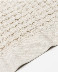A close-up image of the ONSEN Oatmeal Waffle Bath Towel.