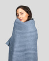 A woman wrapped in the ONSEN Denim Waffle Bath Sheet.