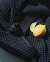 A close-up image of the ONSEN Twilight Blue Waffle Bath Towel with lemon and a slice.