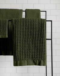 The ONSEN Forest Waffle Bath Towel Set hanging on a rack.
