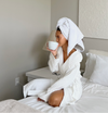 Woman in a White Onsen Bathrobe and towel on the bed. 